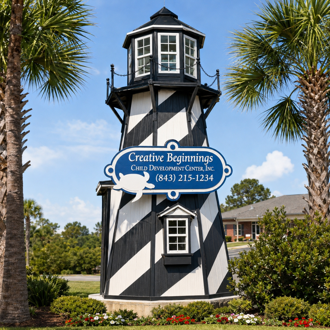 Our iconic black-and-white striped lighthouse with the Creative Beginnings sign, surrounded by palm trees and flowers